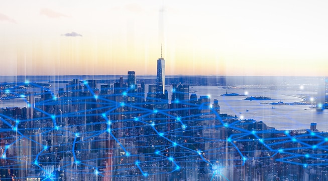 Cityscape with blue network overlay representing IoT and AI connections.